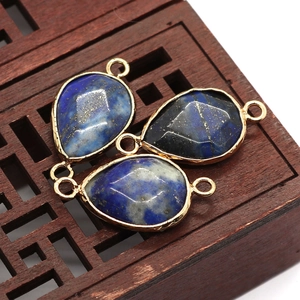 Macro detail of three faceted teardrop Lapis Lazuli pendants with gold plated connectors