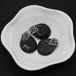 Detail of tear-shaped black agate pendants featuring Evil Eye motifs and rhinestone charms