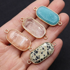 Detail of four oval gemstone connectors with gold-plated edges for DIY jewelry making