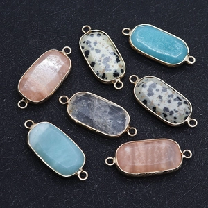 Macro detail of oval natural stone connectors with dual-hole metal frames for DIY jewelry