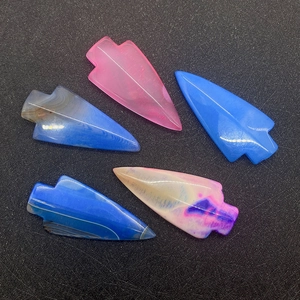 Dettaglio di cinque ciondoli in agata naturale levigati a forma di freccia in vari colori