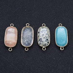 Detail of faceted oval natural stone connectors with gold edges for DIY jewelry making