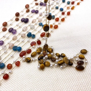 Detailed macro view of gold-plated stainless steel chain with natural stones and pearls