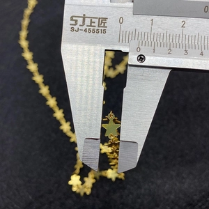 Macro shot of a 9mm gold star pendant link being measured with a precision caliper tool