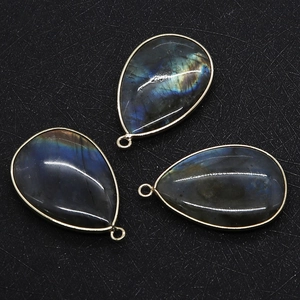 Close-up of three teardrop labradorite pendants with metal edges for DIY jewelry making