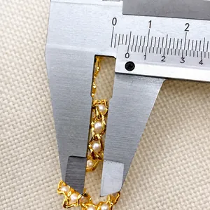 Detailed macro shot measuring 8mm gold mesh chain width with white pearls