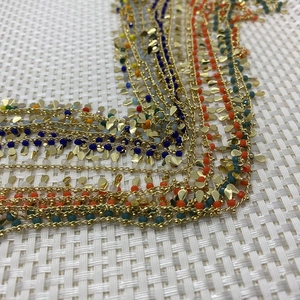 Detail of colorful beads and gold leaf pendants on multi-layer gemstone chains