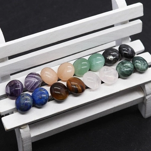 Macro shot of polished oval natural stones including amethyst and aventurine on a mini bench