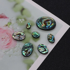 Vue macro de cabochons ovales en nacre d'abalone irisée pour la création de bijoux