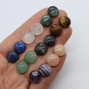 Hand holding assorted 12mm round semi-precious natural stone cabochons for DIY jewelry