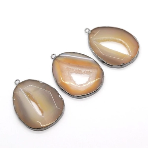 Tre ciondoli drusy in geode di agata irregolari con bordi placcati in argento su sfondo bianco
