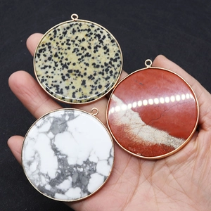 Detailed view of large round natural stone pendants with elegant gold metal edging detail