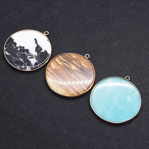 Détail de pendentifs ronds en pierre naturelle avec monture dorée pour bijoux DIY