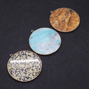 Macro detail of round natural stone pendants with gold metal edging and diverse textures