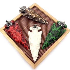 Détail de pendentifs en corne de résine avec calottes en strass brillants en quatre couleurs