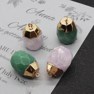Macro detail of faceted natural stone pendants in green and purple with gold caps