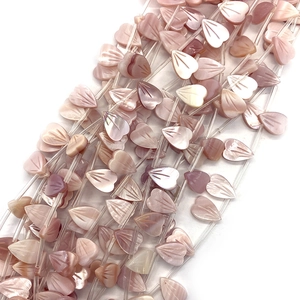 Primer plano de cuentas de concha natural en forma de corazón con grabado floral