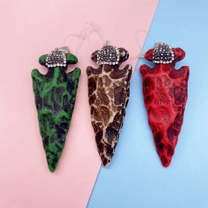Détail de pendentif en flèche avec texture pierre et capuchon en strass colorés