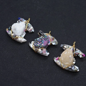 Detailed view of handmade C-shaped crystal pendants with wire wrapping and pearls