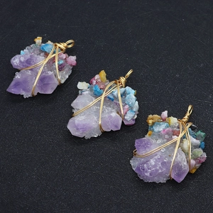 Makroaufnahme von handgefertigten Amethyst-Anhängern mit Golddrahtwicklung auf Schwarz