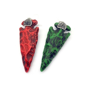 Vue détaillée de pendentifs flèches en résine avec texture lave et fermoirs argentés strass