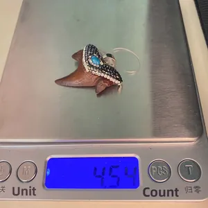 Ciondolo dente di squalo con pietre e turchese su bilancia che mostra il peso di 4,54g