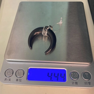 Detail view of crescent moon pendant with rhinestones on a scale weighing 4.44g
