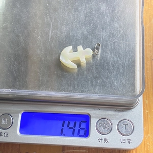 Pendaglio a forma di ancora in conchiglia naturale da 1,46g su bilancia con gancio