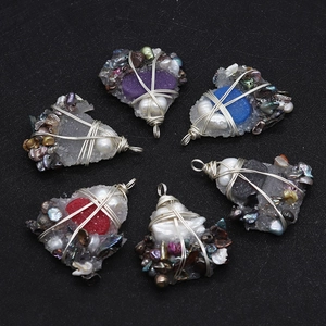 Detailed macro view of heart-shaped crystal pendants with wire-wrapped pearls and shells