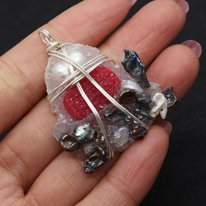 Detailed view of handmade silver wire wrapped natural pearl and red raw stone pendant