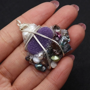 Macro view of handmade wire-wrapped purple crystal pendant with mixed pearls details