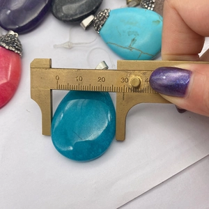 Misurazione di un ciondolo in pietra di 31 mm con un calibro a corsoio in ottone
