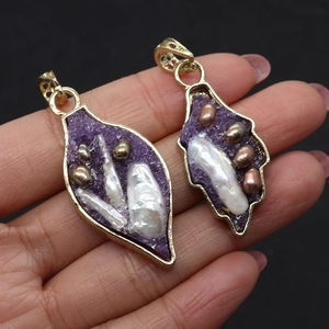 Détail de pendentifs en forme de feuille dorée avec perles naturelles et cristaux mauves