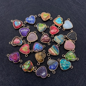 Vue macro de pendentifs cœur en pierre naturelle colorée avec bordure dorée