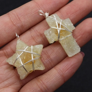 Detailed macro of handmade star and cross natural gemstone pendants with wire wrapping