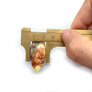 Macro shot of 12mm marquise natural stone pendant with colorful sediment textures