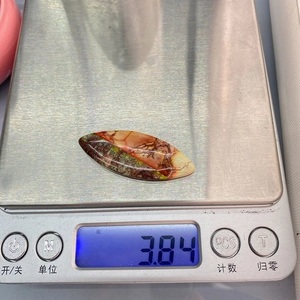 Macro shot showing the 3.84g weight of the oval Imperial Stone pendant on a digital scale