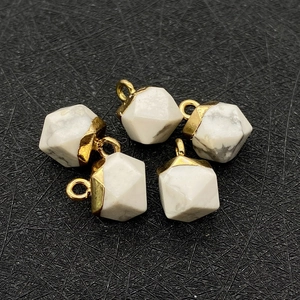 Nahaufnahme von fünf facettierten weißen Marmorstein-Anhängern mit Goldmetallkappen