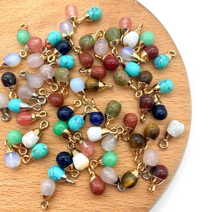 6x13mm teardrop natural stone pendants with gold and silver bails on a wood tray