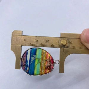 Macro detail van de druppelvormige keizerlijke steen hanger met zilveren rand en regenboogstrepen