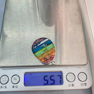 Macro-opname van een 5,57g kleurrijke imperiale steen hanger op een digitale weegschaal