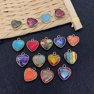 Detalle de colgantes de corazón en piedra natural de colores con marcos dorados para joyas DIY