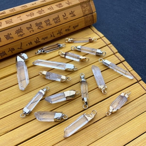 Natural white crystal point pendants with gold and silver metal caps on bamboo mat