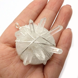 Natural white crystal druzy pendant with silver wire wrap craftsmanship held in hand