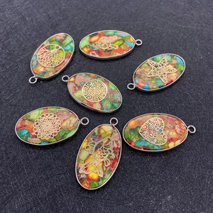 Vue macro de pendentifs en pierre ovale avec motifs dorés comme l'arbre de vie et koi