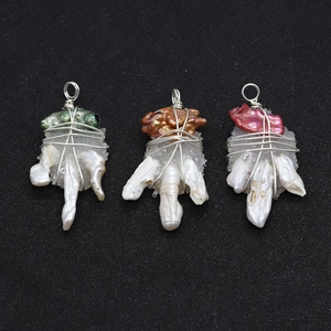 Detailed macro view of three handmade wire-wrapped baroque pearl pendants with crystals