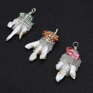 Detailed view of handmade silver wire wrapped baroque pearls and crystals on black background
