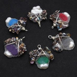 Macro detail of handmade wire-wrapped freshwater pearl and resin pendants in various colors