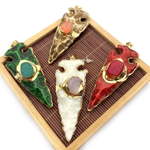 Détail de pendentif en pointe de flèche avec pierres naturelles et bord doré