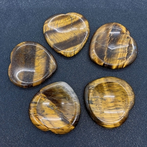 Detailed close-up of heart-shaped tiger eye stones with natural golden brown stripes